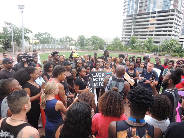 Protesters gather at Romare Bearden Park after marching through the rain to protest police brutality. - RYAN PITKIN
