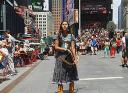 Apache Stronghold youth leader Naelyn Pike, Nosie's granddaughter, stands in Times Square while touring to raise awareness about the fight for Oak Flat. - STANDING FOX