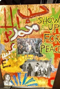 Artwork painted on the boards that once served as replacements for the windows of the Hyatt House that were smashed during protests.
