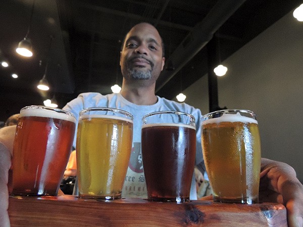 Tabu Terrell with a flight of beers. Photo by Ryan Pitkin.