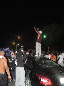 Jamil "King Millz" Gill stands atop a car he was driving to capture the protests on a live stream on Sept. 20.