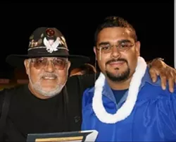 Banda's proud father (left) beams on his son's high school graduation day in 2005.