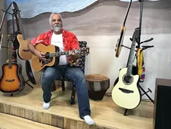 Beeler strums a few chords on the first guitar he ever bought, a old Yamaha FG-300.