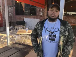 Tony Potts, aka Phaze Gawd, has a 'Dark Dreams' tee for you, too. Here he is on the patio at the Rhino Market in Wesley Heights. (Mark Kemp)