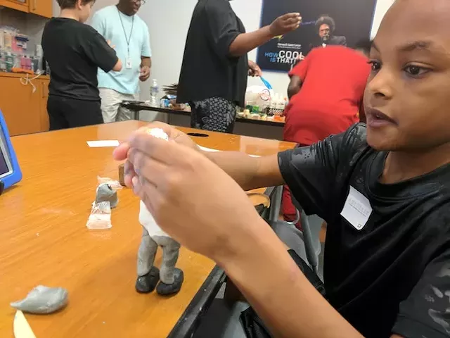 Kaison Ingram, 9, builds a clay model at the recent workshop. (photo by Ryan Pitkin)