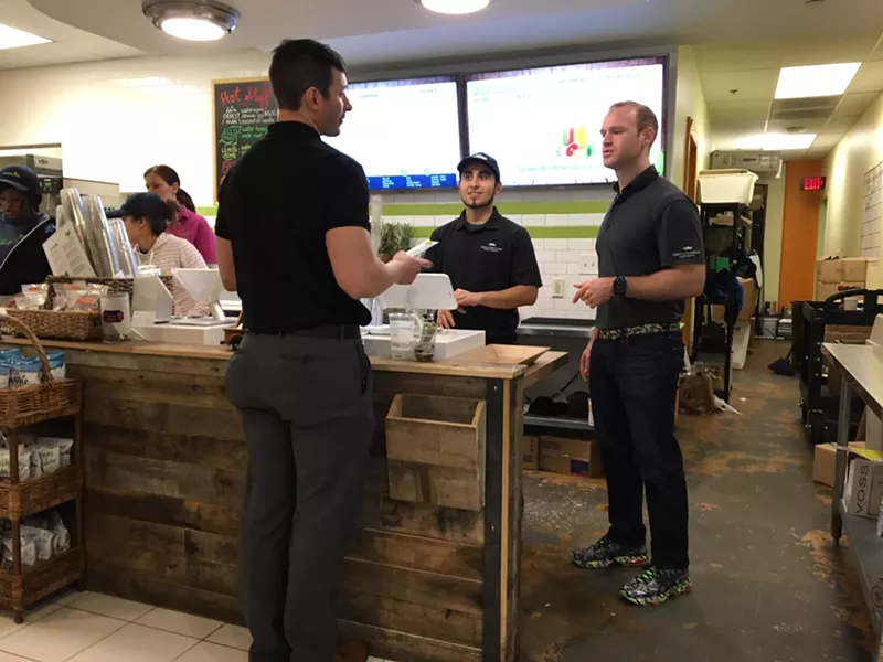 Josh Norris (right) chats with customer Brett Ezarsky at Green Brothers' Bank of America Plaza store