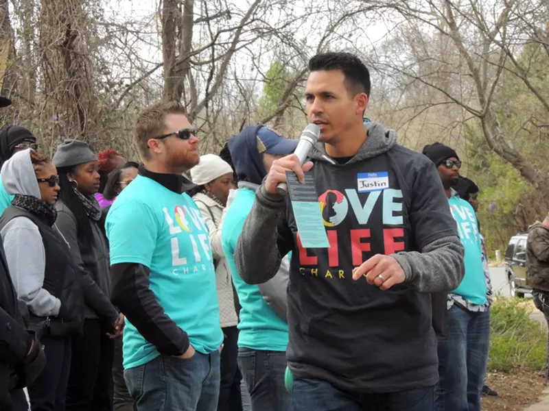 Justin Reeder of Love Life Charlotte speaks to church members standing in front of PWHC. - RYAN PITKIN