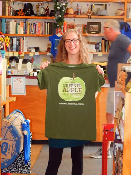 Lee Rathers, owner of The Greener Apple, showing off some gear from the food shop within a store.