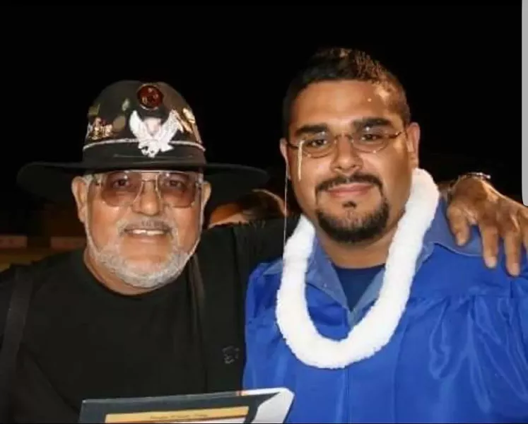 Banda's proud father (left) beams on his son's high school graduation day in 2005.