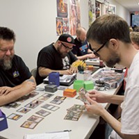 (From left) John Hartness, Jake Strunin and Owen Tavener play Magic: The Gathering at Rebel Base during a Monday night event.