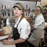 As sous chefs, Miranda Brown (left) and Ansley Rawlins work on food prep in the 300 East kitchen under the guidance of pastry chef Ashley Boyd (not pictured). (Photo by Jeff Hahne)