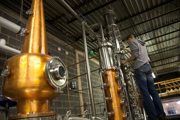 Andrew Porter, owner of Doc Porter’s, adjusts valves during the distilling process. (Photo by Jeff Hahne)