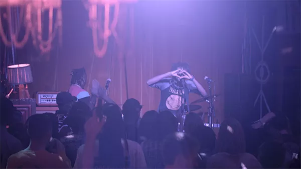 Funderburk hides behind heart-shaped hands during a June 13 Deion Reverie show at Snug Harbor. (Video still by Deion Funderburk)
