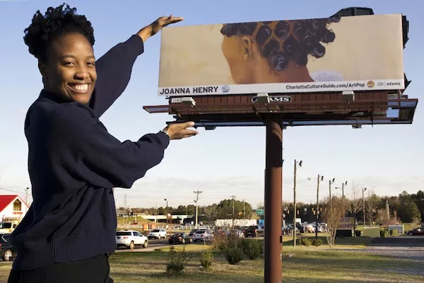 Rock Hill artists and ArtPop alum Joanna Henry poses with her billboard in York County, South Carolina.