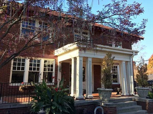 Mardi Gras beads, thrown by children, hang from the trees outside of the historic Cajun Queen building. (Photo by Ryan Pitkin)