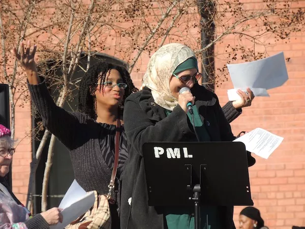 Rose Hamid speaks at First Ward Park, as Regina Grover cheers her on from behind. (Photo by Ryan Pitkin)