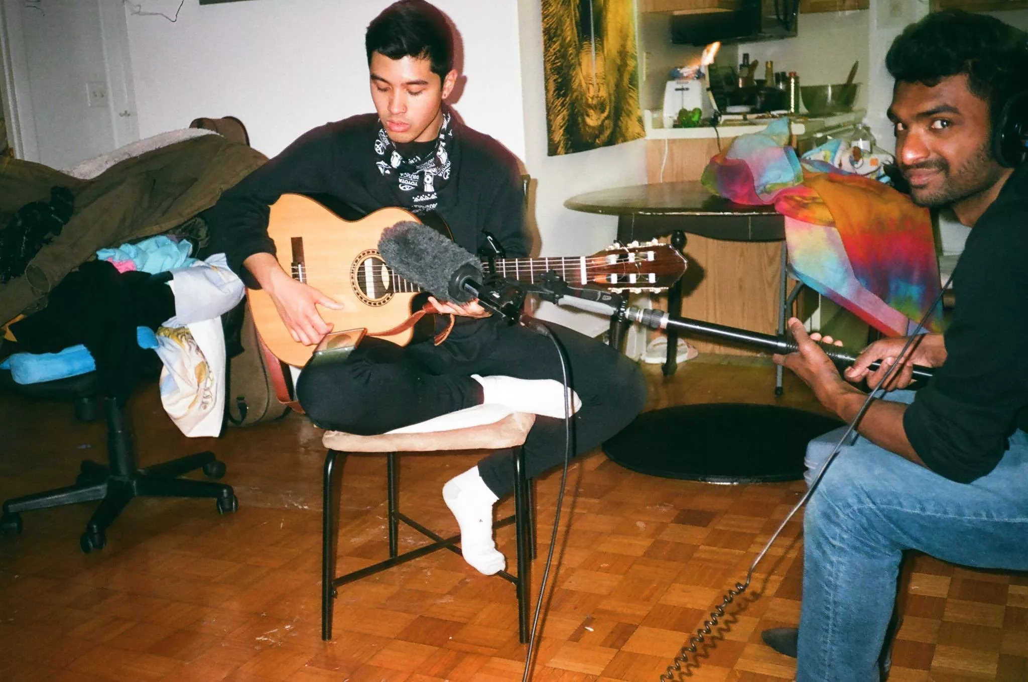 Quisol strums an acoustic guitar at Hermit Mo Studios in December. (Photo by Mo Kwok)