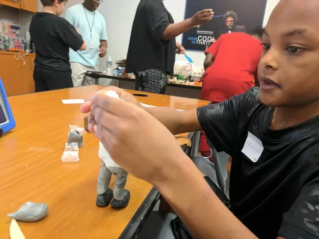 Kaison Ingram, 9, builds a clay model at the recent workshop. (photo by Ryan Pitkin)
