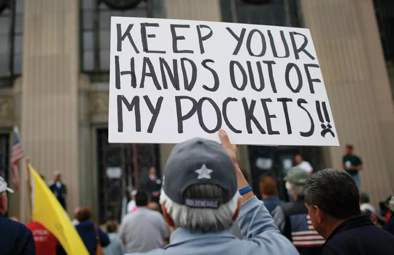 A man holds a sign at a tax day rally by Tea Party activists in New York City, Rockland County, on April 15, 2010.