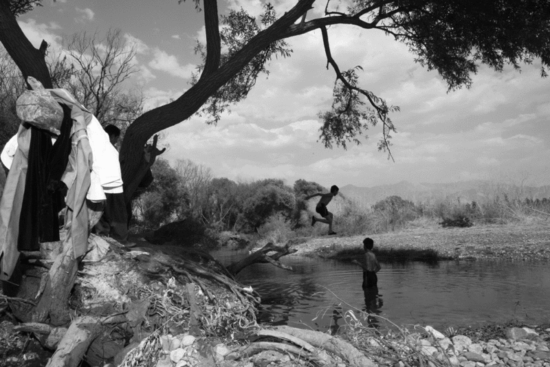 Against the backdrop of the Zagros Mountains in Kurdistan, boys attending a nearby wedding sneak off for an afternoon swim. - LORNA TYCHOSTUP