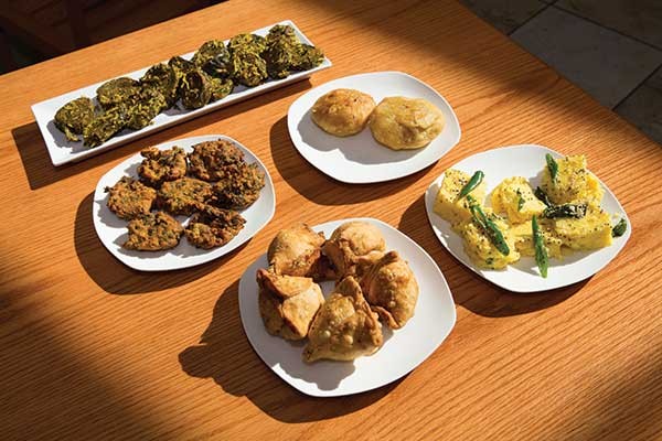 Appetizers clockwise from top left: patra pinwheel; khasta kachori; khaman; samosas; spinach pakora - KAREN PEARSON