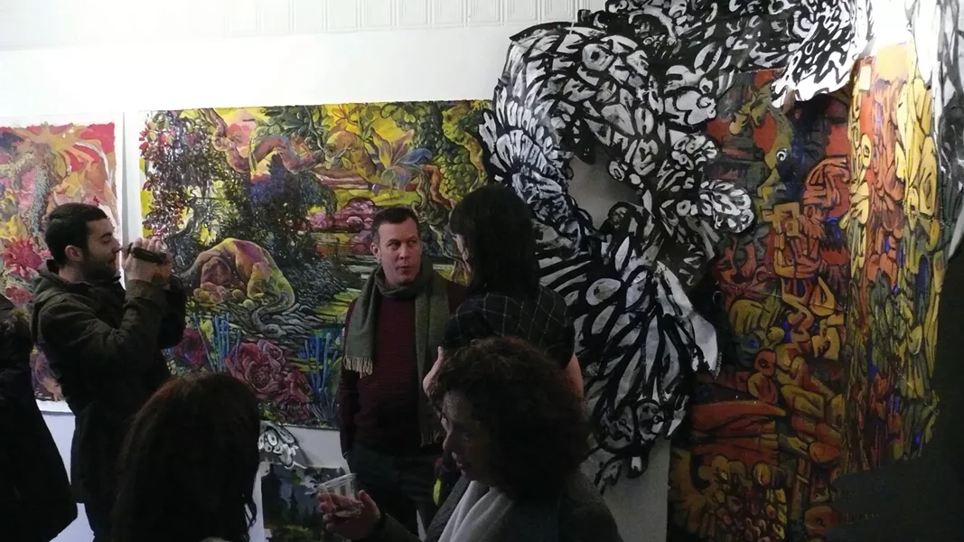 Artist Paul Spaldone (wearing scarf) being interviewed at the opening of his one-man show "The Monstrous Among Us: Folly, Excess, Collapse" at Team Love Raven House Gallery in New Paltz on February 11. - NATE KRENKEL