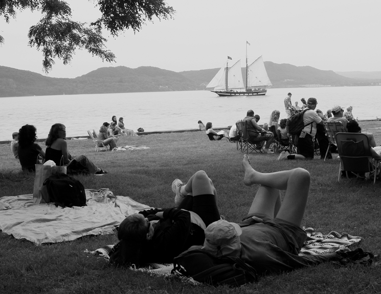 Clearwater Festival attendees lounge and watch the sloop Clearwater pass at the 2006 Great Hudson River Revival.