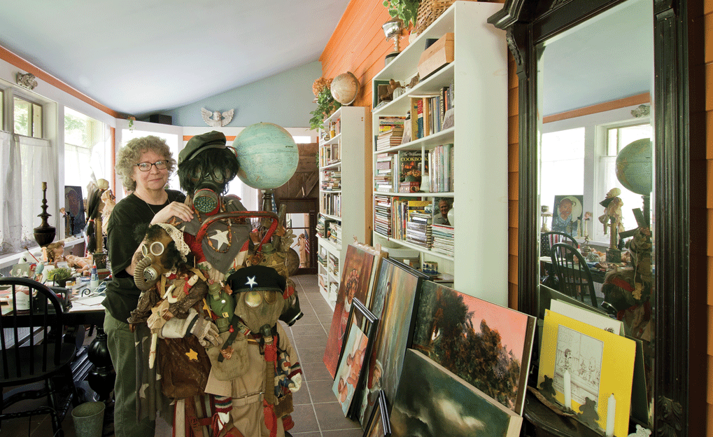Jacquie Roland stands behind her assemblage “Mother Courage” in her dining room. - DEBORAH DEGRAFFENREID