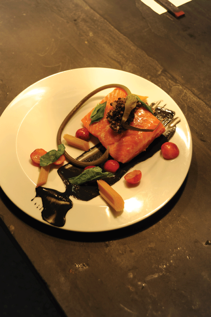 John McCarthy, Ben Freemole, and Andrew Speilberg plating a dish of steelhead trout with squid ink, yogurt, lentils, garlic scape, and sorrel. Photo by Roy Gumpel.