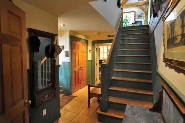 Opposite, below: Entry: the lower floor entry is decorated with wainscoating, door frames from the Manhattan loft building, doors from the Door Jamb on Rt. 28, antiques from local garage sales, and tiles from Nelson’s in Saugerties. - PETER BRANDT
