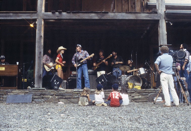RCO Picnic Rehersal, Summer 1977 - “Amy watching her dad rehearse. The entire crew at the barn was gearing up for a big summer picnic Levon was throwing for RCA records. On stage from the far left is Mac Rebennack [aka Dr. John], Steve Cropper, Elizabeth Barraclough, Fred Carter, Jr., Donald ‘Duck’ Dunn, Paul Butterfield, and Levon. I was charmed by the sight of this all-star band playing their hearts out for an audience of Amy and her friends.”