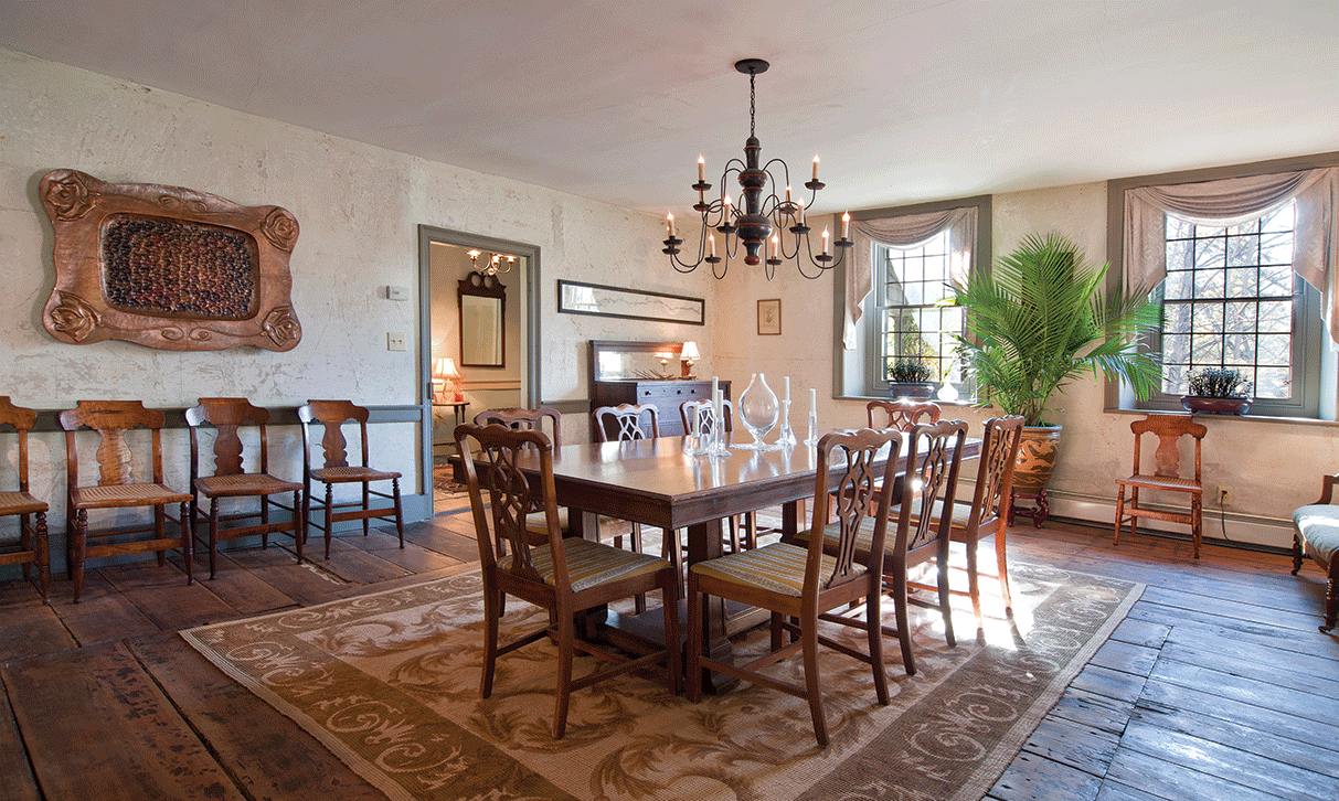 The dining room features a former library table that came with the house as its centerpiece. The artwork on the rear wall is by Myra Mimlisch Gray. - DEBORAH DEGRAFFENREID