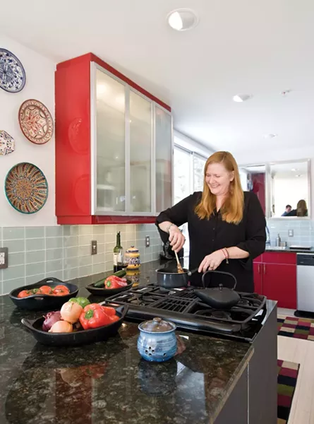 The semi-open kitchen features a downdraft range, glass tile back-splash, Ikea cabinets, and ceramic plates from Spain and Morocco. Piedrahita and Gude wanted the cooking experience connected to the living and dining areas, and the view of the mountains. - DEBORAH DEGRAFFENREID