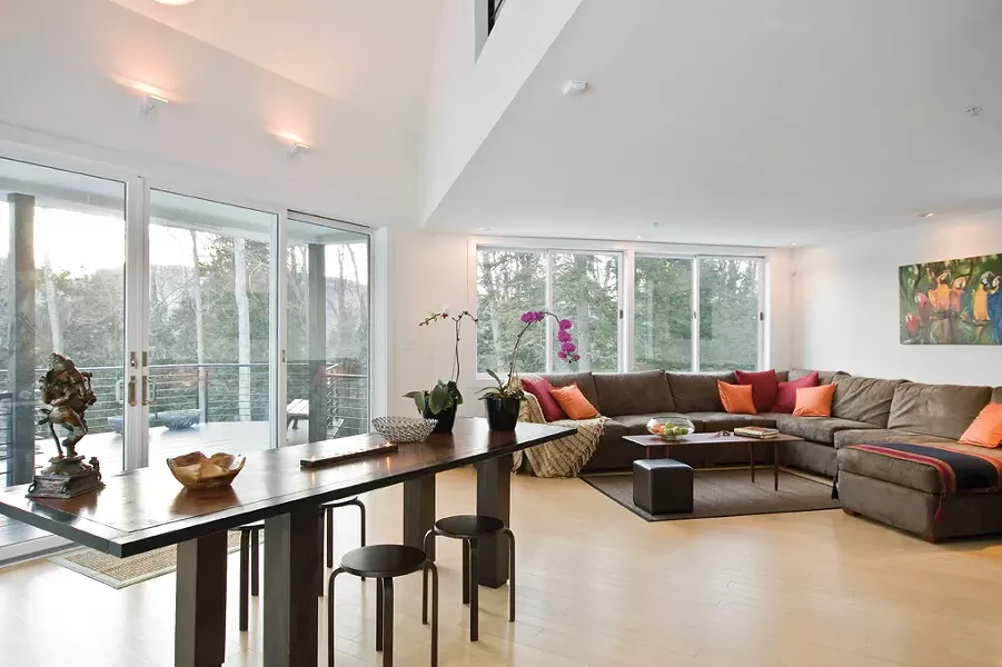 The social floor is open to the mountains and the mid-afternoon sun. The dining table was made from a reclaimed old table top found in a barn in the Catskills; high ceilings in the open space visually connect the floors. - DEBORAH DEGRAFFENREID