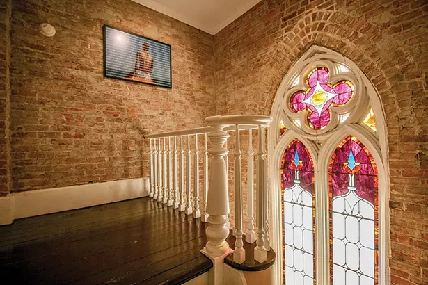 A landing at the top of the stairs features original wide plank floors. Bokaer converted the church’s former stepped choir loft into a bedroom with an open seating area, by leveling the floors and then carpeting them. - PHOTO BY SETH DAVIS