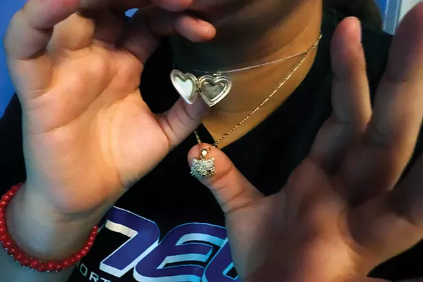 Karicia: “The heart pendant was a gift from Karicia’s father. Inside is a photo of them together. The cat pendant was the last thing her father gave her for being strong through her leukemia treatments. ‘My first attempt was in school,’ says Karicia. ‘I brought a knife to slit my - wrists in the girls’ bathroom. I felt like my mom didn’t care about me anymore. She didn’t call me, she didn’t text me, she didn’t reach out to me to see if I was ok.’” - PHOTO BY IYANNA MORENO