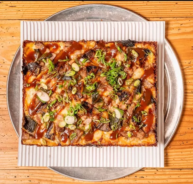 The El Camino features caramelized pineapple, roasted poblano, slow-roasted pork shoulder, Stubbs BBQ sauce, parmesan.