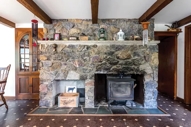 The dining room features the original bluestone fireplace with a woodstove. The home has two other woodstoves which can heat the house throughout the winter. “I cut a lot of wood during the summers,” says Zimmerman. “In winter, the home has a nice homey feeling inside.” - WINONA BARTON-BALLENTINE