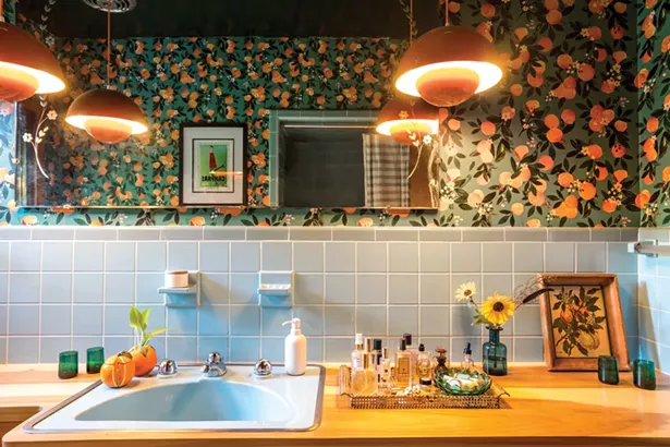 The primary bathroom required a complete overhaul. Salvemini found the blue mid-century sink, faucet, and handles on eBay. “That was - a whole journey in antique plumbing that I never need to experience again,” she says. She restored the original blue tile and replaced the countertop. The blue and orange design, along with the orange pendant lamps, were inspired by her favorite orange-scented perfume. “I find great satisfaction creating meaningful sensory experiences for others in my designs,” she says. - WINONA BARTON-BALLENTINE