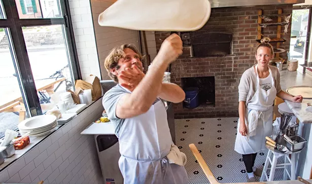 Adam Monteverde and Lauren Mias behind at the counter at Apizza!, a new coal-fired pizza parlor in New Paltz. Photo by Benjamin Cotten