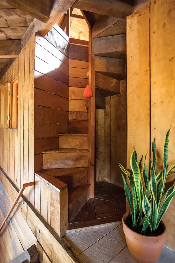 A winding wooden staircase leads to the home’s third and fourth floors. A Juliet window opens to look down on the main living room. These extra, architectural flourishes are some of Jones’s favorite features of the house. “I love the way children light up when they realize there are two secret floors and a Juliet window,” says Jones. Once used as extra sleeping space, Jones wants to put a ham radio on the fourth-floor landing. - WINONA BARTON-BALLENTINE