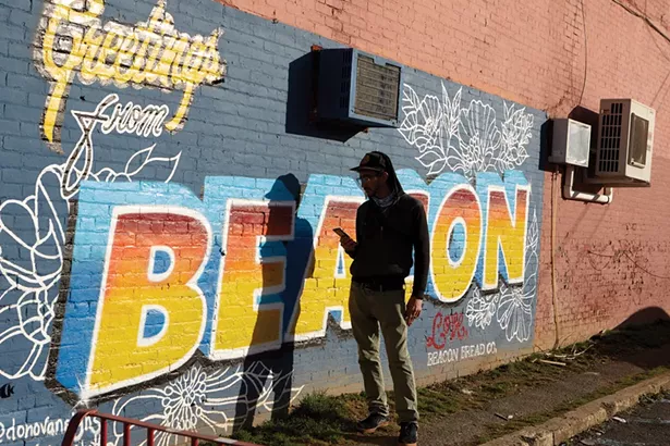 Local musician Hashishen in front of a mural painted on the side fo the Beacon Bread Company building by artists Sean Donovan and Shanon Ramos. - DAVID MCINTYRE