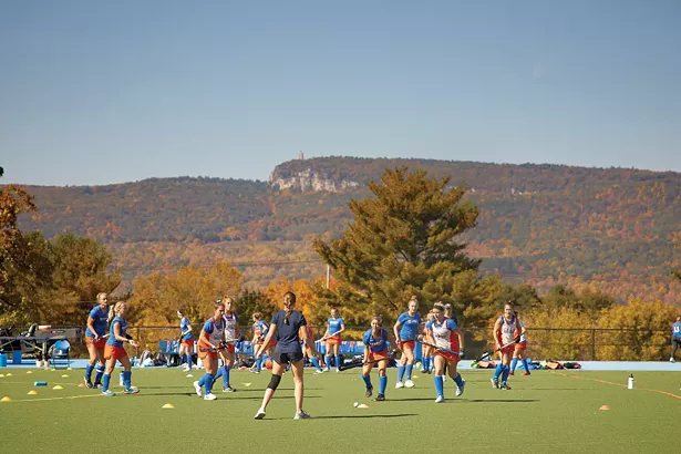 The SUNY New Paltz women’s varsity field hockey team practicing on campus. The iconic Skytop tower is in the background. - DAVID MCINTYRE