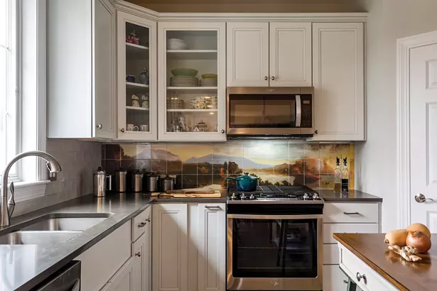 After choosing a modular layout, Edwards worked with general contractor Debra Benjamin to personalize the home’s design. In the kitchen, she created a colorful backsplash inspired by the Hudson River School of landscape painting. She then commissioned the Colorado-based company Enduring Images to print the painting on tiles. - WINONA BARTON-BALLENTINE