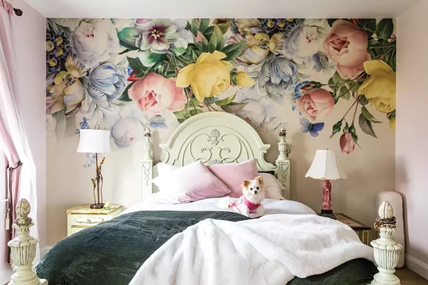 The home’s design features three bedrooms, with the primary bedroom suite tucked away down - a gallery-like hallway at the back of the home. With views to the pond, Edwards had fun with the colorful wall design. She found the wallpaper print painting online and then hired a local contractor to install it. Her dog Hazel enjoys the relaxing space. - WINONA BARTON-BALLENTINE