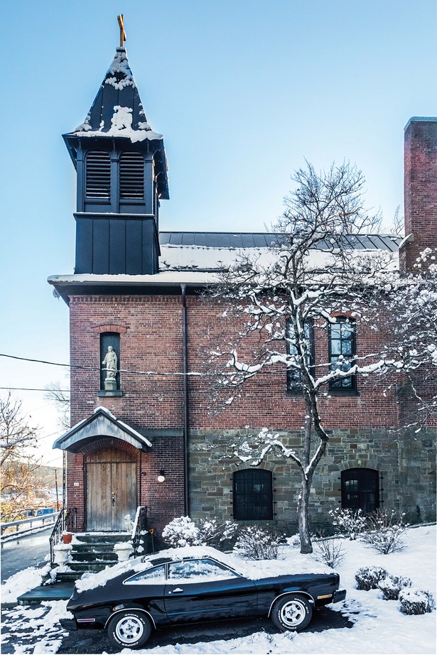Colborn Bell’s home, the former Sacred Heart of Jesus church, sits on a hillside in the hamlet of Wilbur in Kingston. Built in 1884 to serve the local population of bluestone masons, carpenters, and shipyard workers, the church overlooks Feeney’s shipyard. A former owner refurbished the church’s locally sourced red brick walls and replaced the asphalt roof with metal and added copper gutters. - WINONA BARTON-BALLENTINE