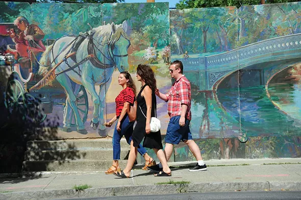 Walking past murals on Warren Street in Hudson. - ROY GUMPEL