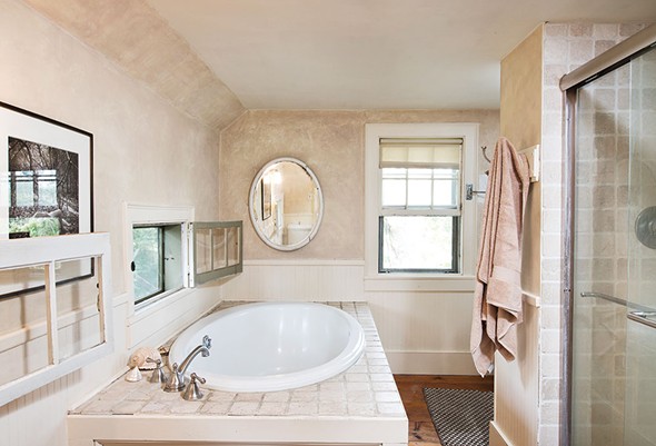 Upstairs, Shaff captured space from a front bedroom to build her dream bathroom. This includes a soaking tub with bird’s eye view out the casement windows. - DEBORAH DEGRAFFENREID