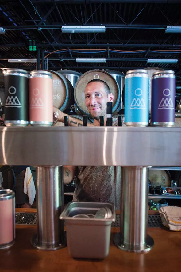 Grady Salter pouring brews. - PHOTO BY CHRISTINE ASHBURN