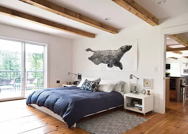 The couple’s bedroom overlooks the back deck and is decorated with pieces inspired by their wooded surroundings. The artwork above the bed, Ursa Major Lost At Sea by Aliene De Souza Howell, was purchased from One Mile Gallery in Kingston. - DEBORAH DEGRAFFENREID